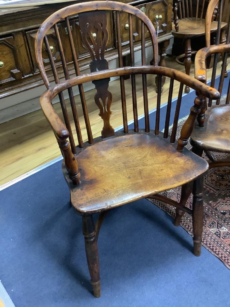 A harlequin set of seven early 19th century yew and elm splat back elbow chairs